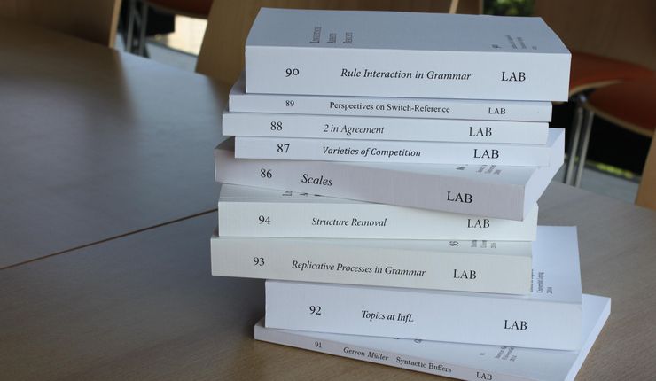 Volumes of the working paper series of the Institute of Linguistics lie on a table