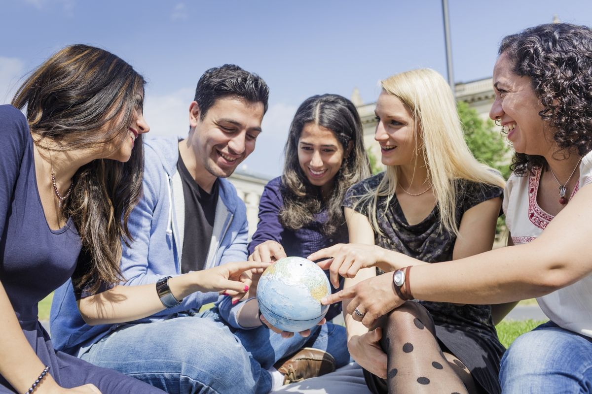 zur Vergrößerungsansicht des Bildes: Fünf Jugendliche verschiedener Nationen halten einen kleinen Globus in der Hand.