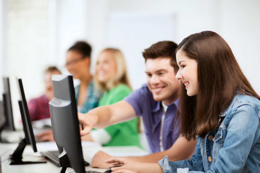 zur Vergrößerungsansicht des Bildes: Studentinnen und Studenten sitzen an einem PC