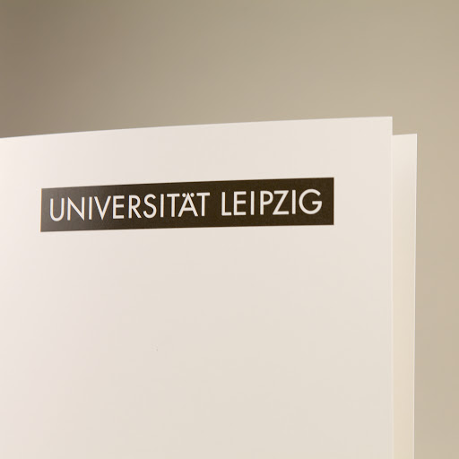 Foto einer Urkundenmappe mit Logo der Universität Leipzig.