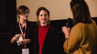Eine Filmemacherin, ein Gast und die Dolmetscherin Klara Flenker im Gespräch.