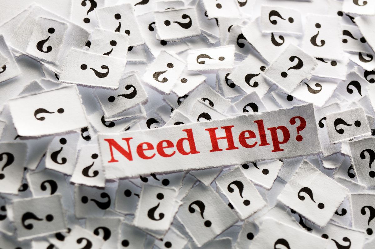 zur Vergrößerungsansicht des Bildes: Viele Papierschnipsel mit Fragezeichen und dazwischen auf einem Zettel in roter Schrift: "Need Help?".