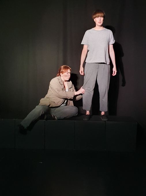zur Vergrößerungsansicht des Bildes: Zwei Darstellende auf der Bühne während der Aufführung des Theaterstücks.
