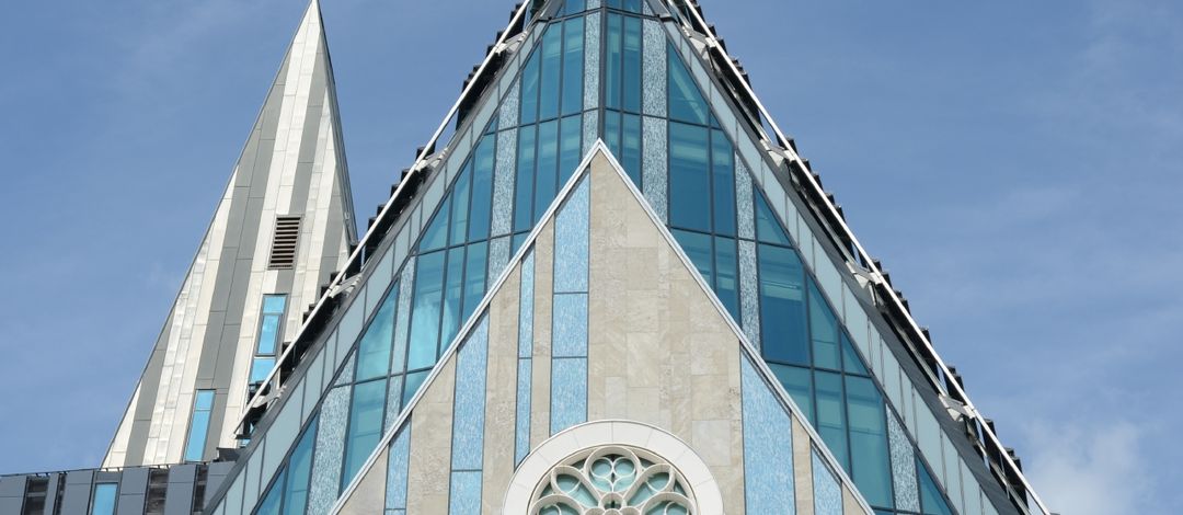Foto: Spitze der Glasfassade des Paulinums bei blauem Himmel