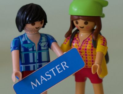 Zwei Playmobilfiguren, im Vordergrund ein Schild mit der Aufschrift "Master"
