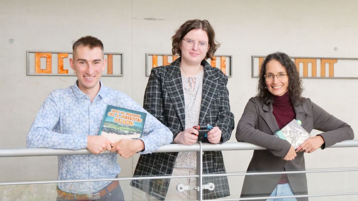 enlarge the image: The researchers pose with copies of Robinson Crusoe and with a gaming controller.