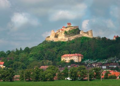 Zu sehen ist eine mittelalterliche Burg auf einem Hügel.