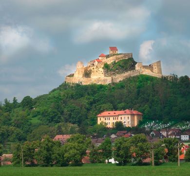 Zu sehen ist eine mittelalterliche Burg auf einem Hügel.