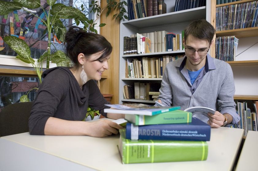Zwei Studiernde sitzen an einem Tisch zusammen und tauschen sich über Lernmaterialien aus, Foto: Christian Hüller