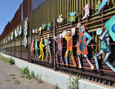 Mural "Paseo de Humanidad" (Parade of Humanity) by artists Alberto Morackis, Alfred Quiróz, and Guadalupe Serrano on the Mexican side of the US border, Image Credit: Jonathan McIntosh, Wikimedia Commons