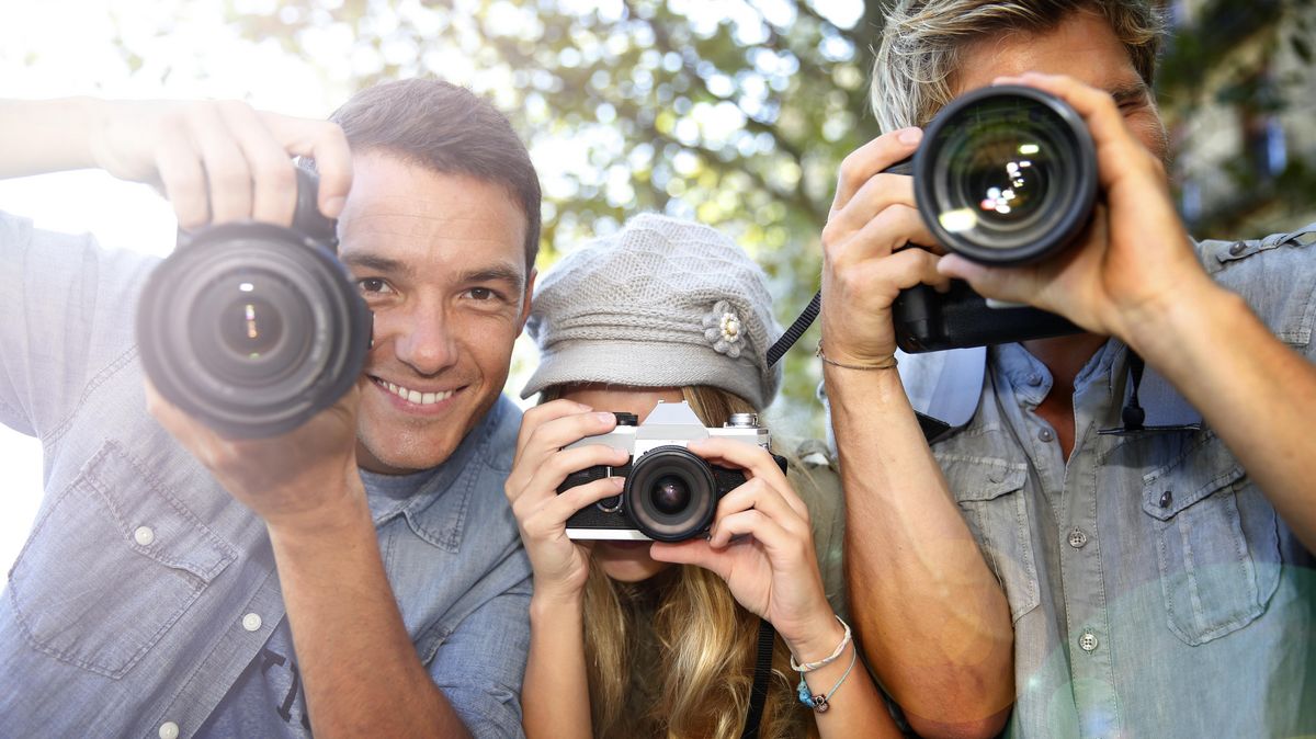 zur Vergrößerungsansicht des Bildes: Drei junge Leute fotografieren mit Fotoapparat.